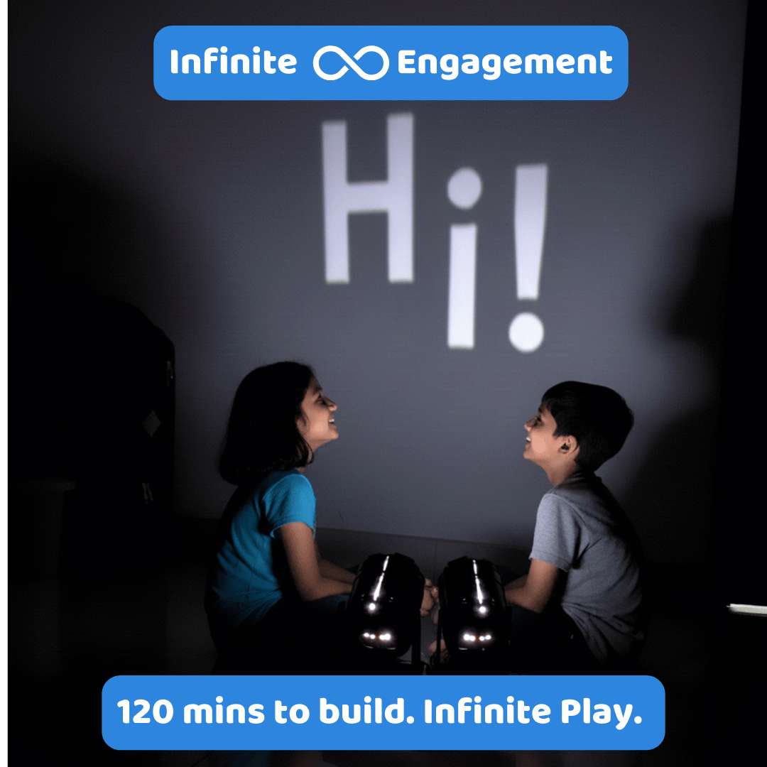 Two children sitting in front of a screen with 'Hi!' projected, promoting 'Infinite Engagement' with text about building time.
